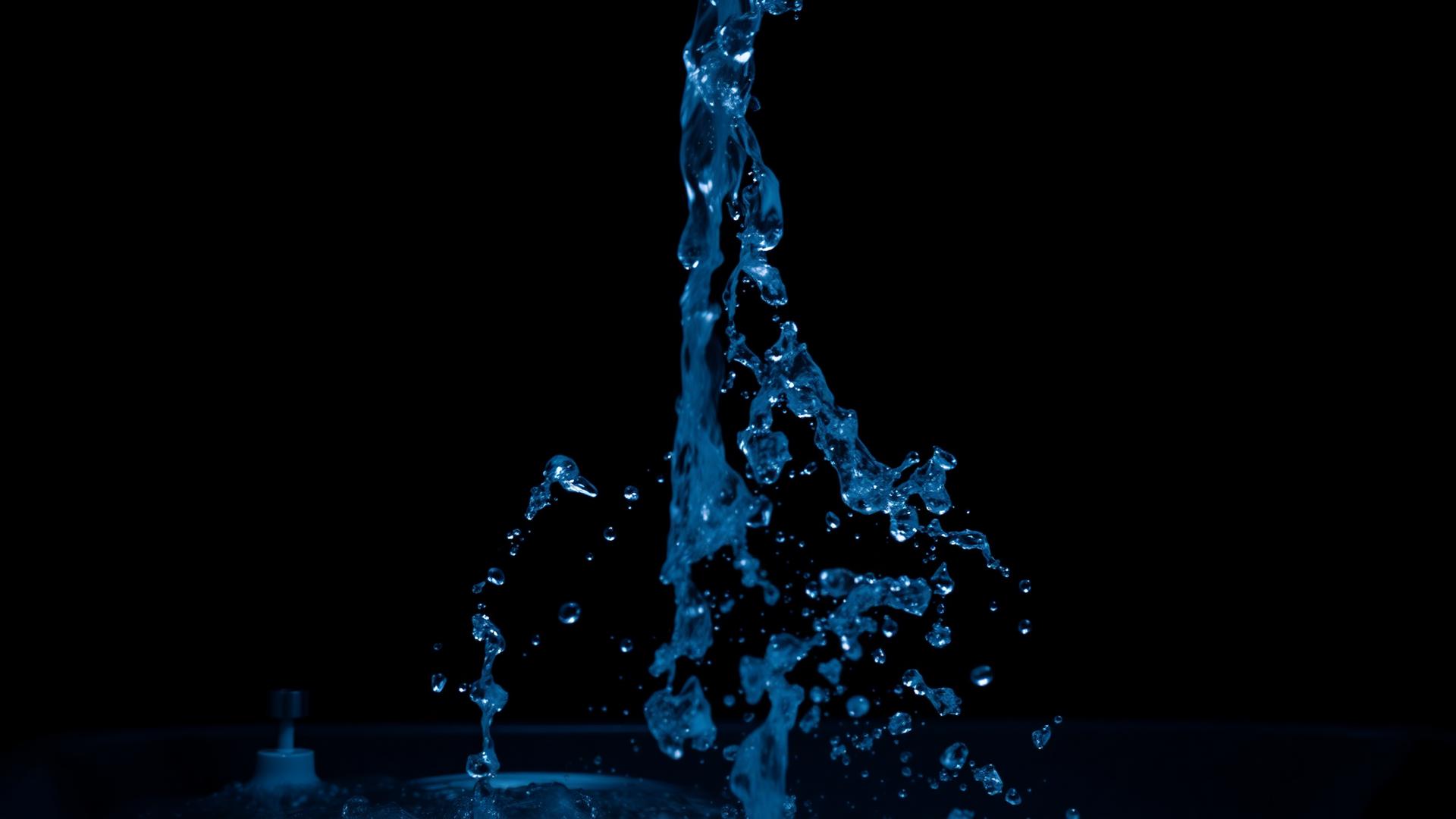 Clean water streaming against a dark background